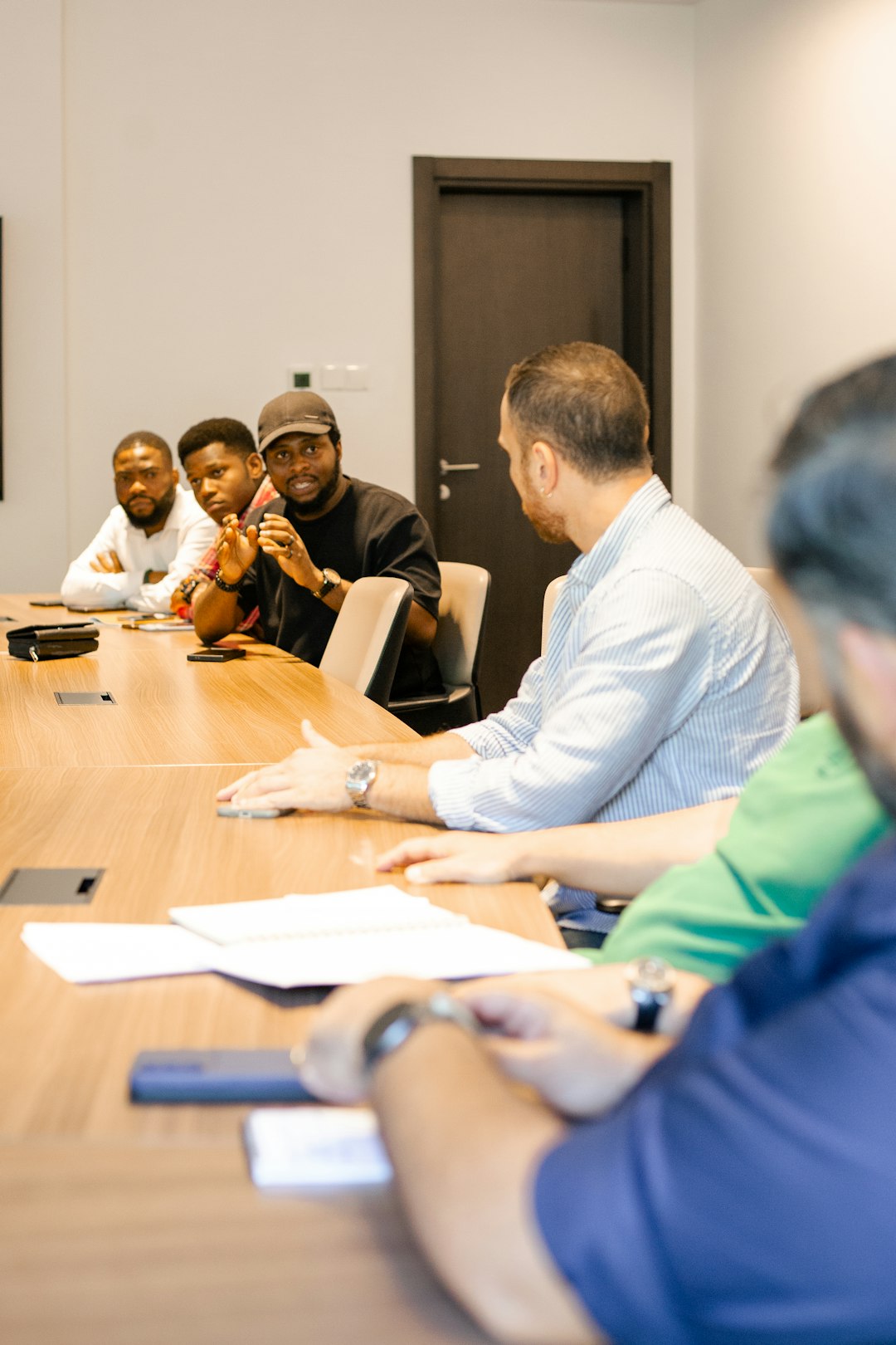 Members of a visiting accreditation team seated around a conference table during a working session