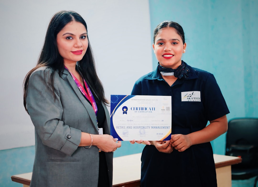 Two people holding a certificate — representing faculty professional licensure and certification requirements