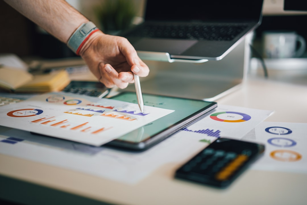 Person using a tablet with data charts — representing market analysis of accreditation tools
