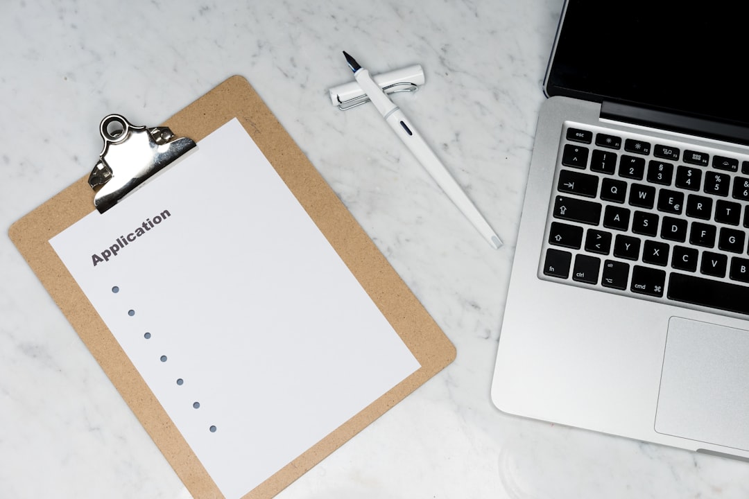 Application forms and documents beside a laptop — representing preparation for the Tandem submission system