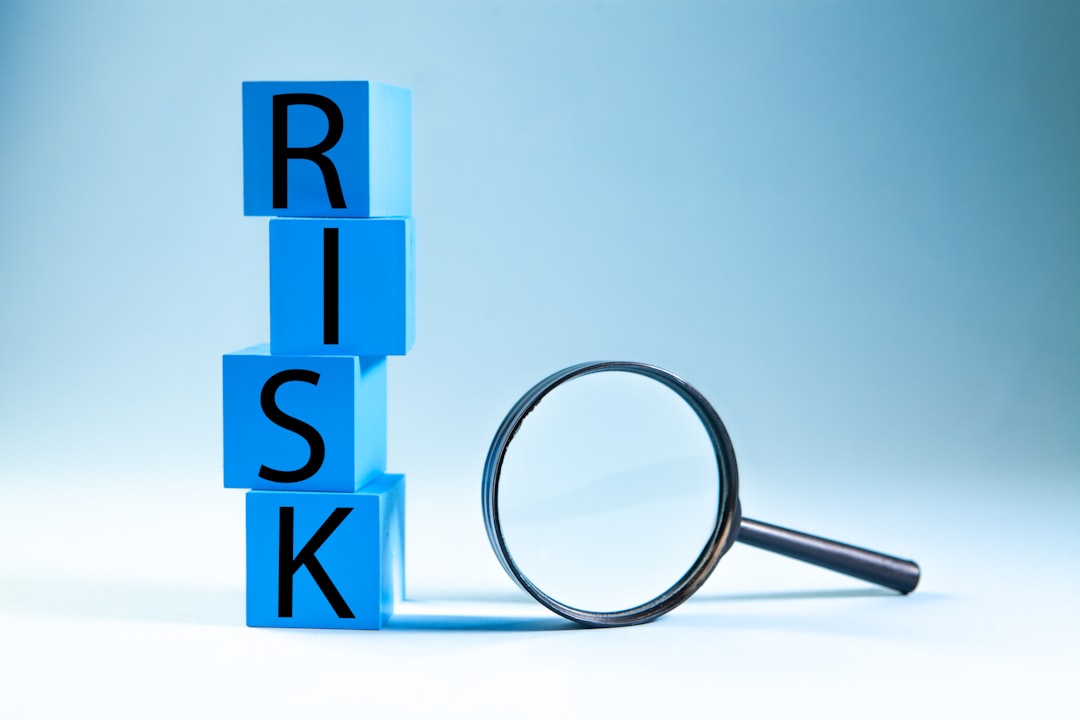 Word RISK on blue cubes with magnifying glass — representing accreditation risk management when gaps are found
