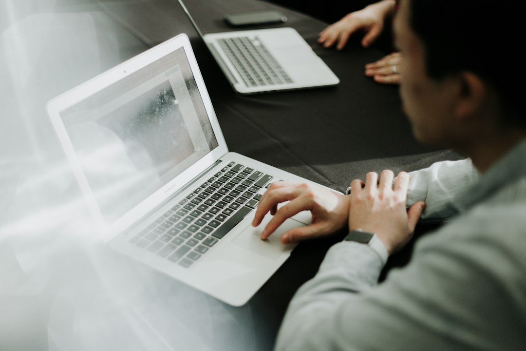 Hands typing on a laptop, working through accreditation documentation