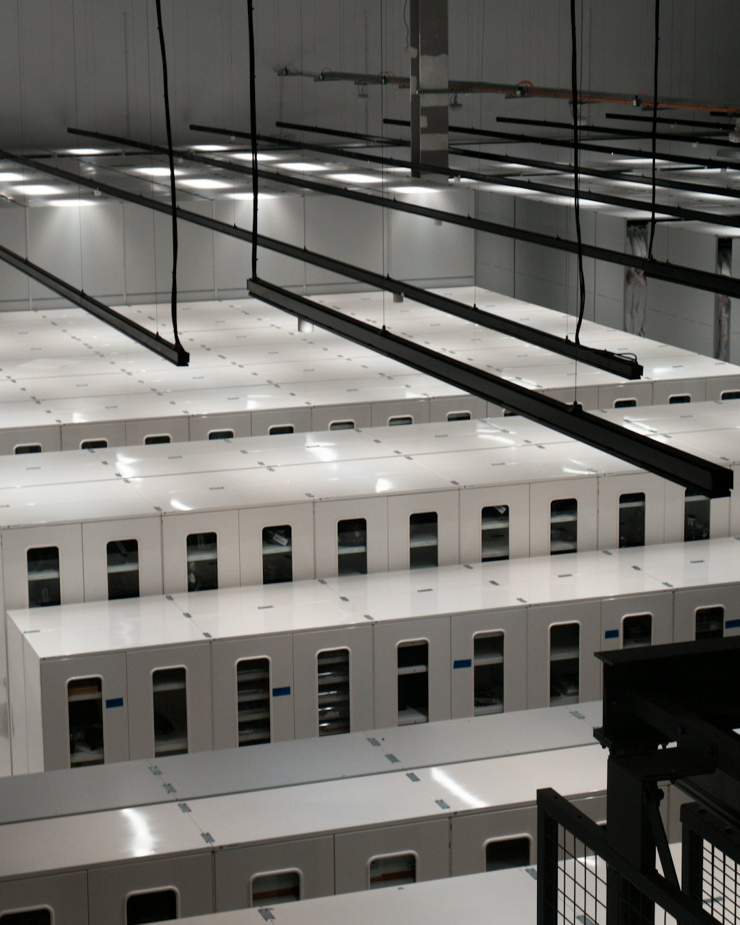Rows of white server cabinets in a modern data center, where accreditation evidence is physically stored
