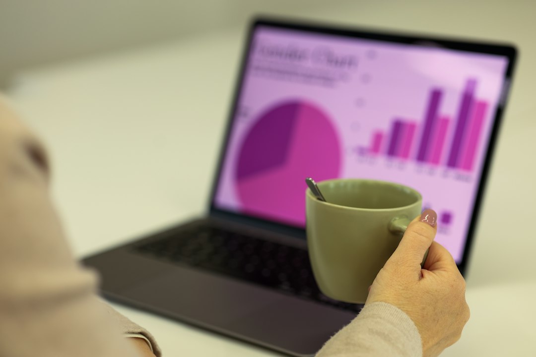 A person reviewing pie and bar charts on a laptop, representing program assessment data being analyzed