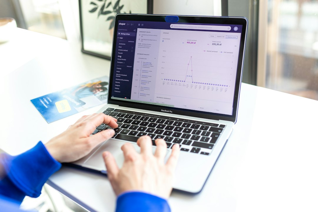 Hands typing on a laptop showing a curriculum map grid with courses and attributes, the matrix at the heart of the review