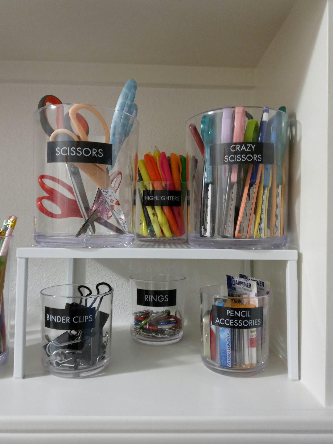 Labeled, organized containers of office supplies on a shelf, the kind of tidy system that keeps evidence current between visits