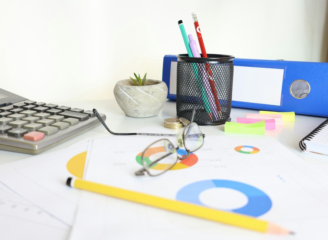 Desk with pie charts, calculator, and binders — analyzing visiting team feedback