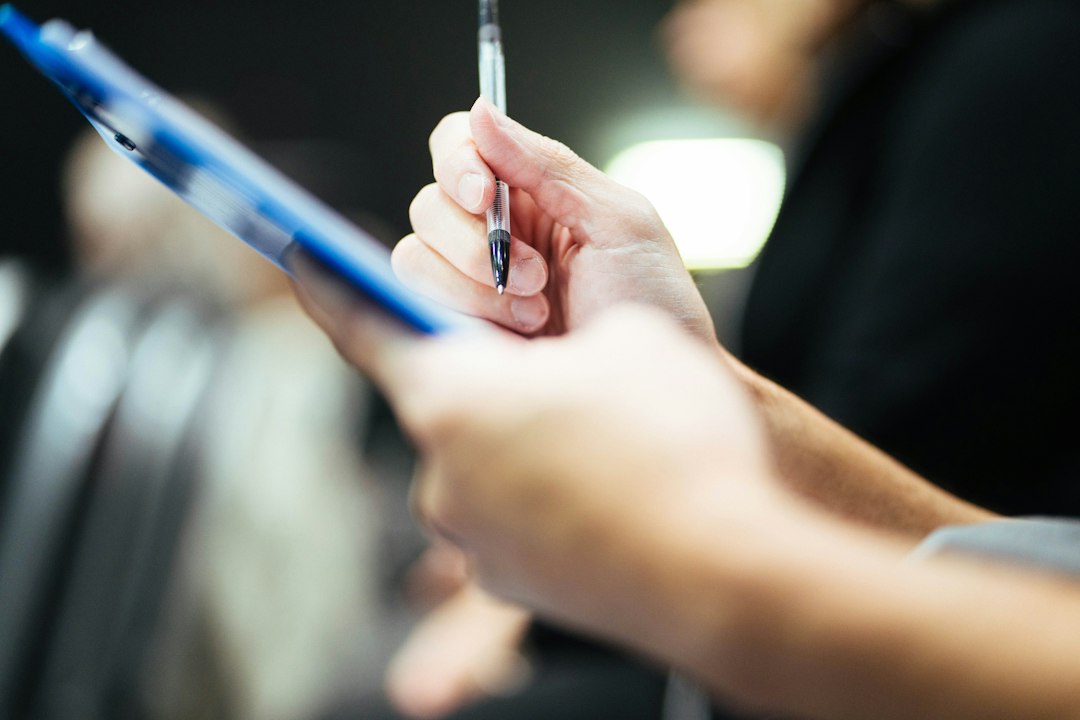 Reviewer holding a clipboard and pen, documenting findings