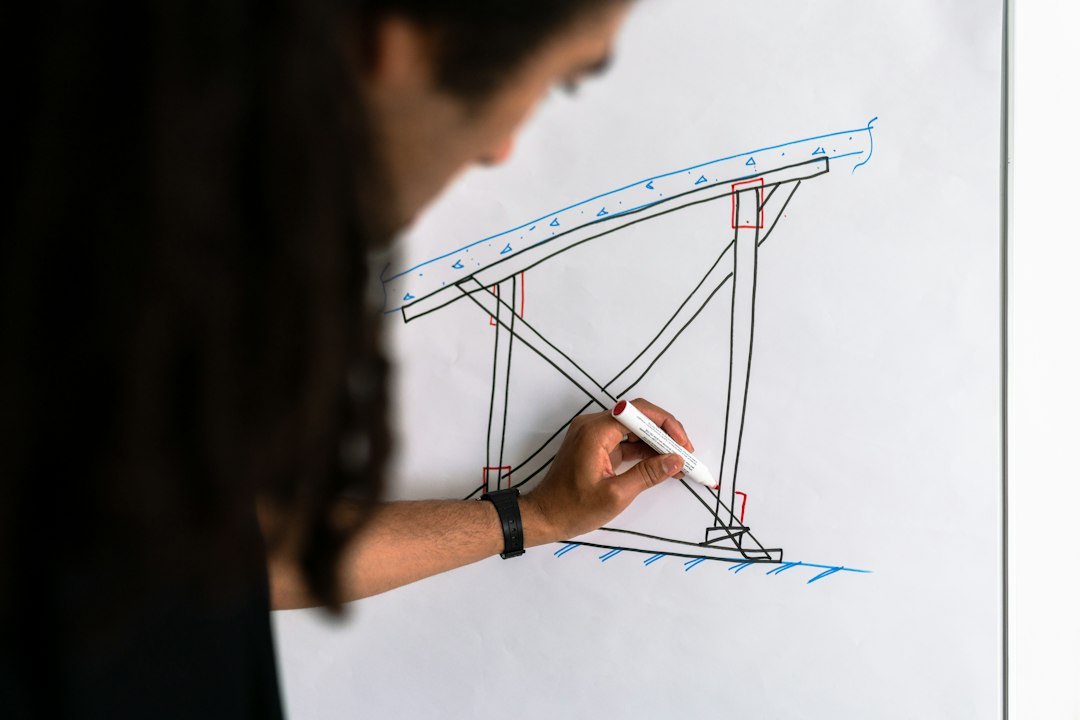 A structural engineer drawing a truss diagram on a whiteboard, the kind of non-linear complexity that a spreadsheet cannot hold