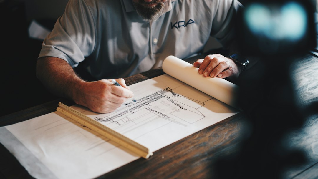 Architect reviewing engineering blueprints and plans at a drafting table