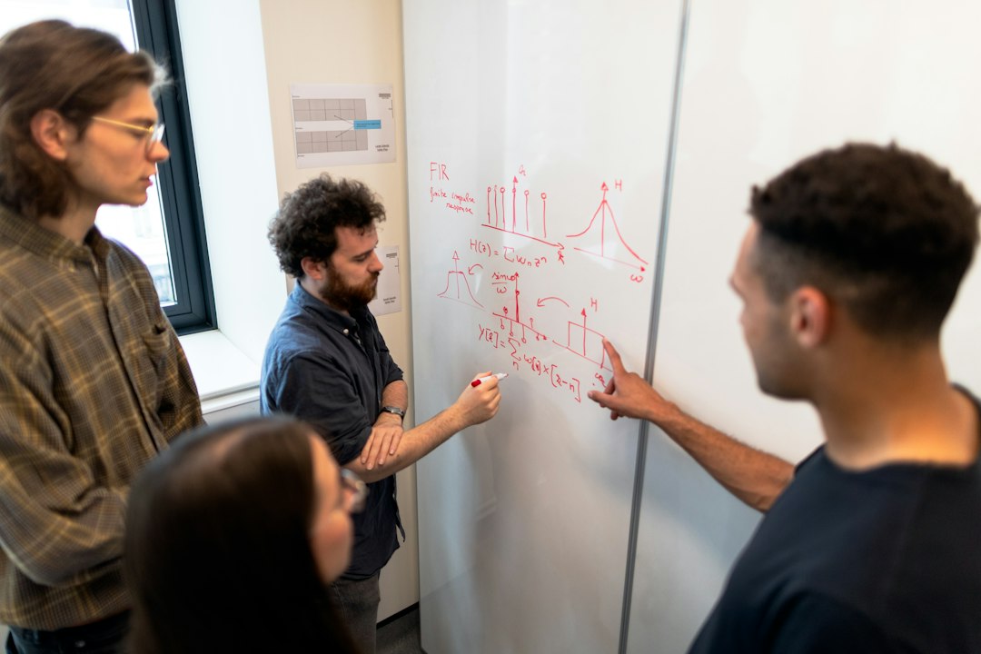 Coordinators and faculty reviewing a self-study outline together at a whiteboard during internal review